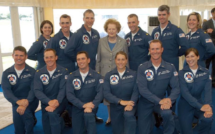Members of a military aerial demonstration team pose with a politician.